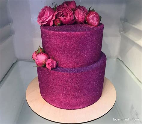 کیک دو طبقه جشن تولد بزرگسال یا سالگرد ازدواج با روکش شاینی سرخابی تزیین شده با گل های طبیعی و