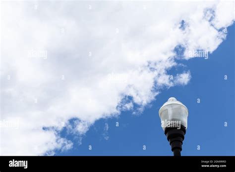 Exterior Light Post With Glass Fixture Isolated Against A Blue Sky With