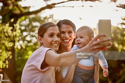 Couple De Lesbiennes Avec Bébé Prenant Un Selfie Dans Le Parc Photo