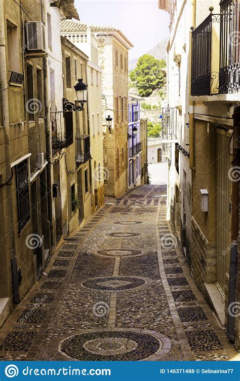 The Cozy Narrow Street Of The Old European City Of Relleu Is Paved With