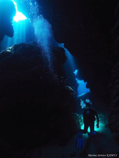 A Man Standing In The Middle Of A Cave With Scuba Gear Under His Arm
