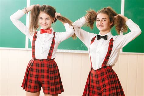 Zwei Hübsche Schulmädchen Im Schuluniformstand Mit Büchern Im