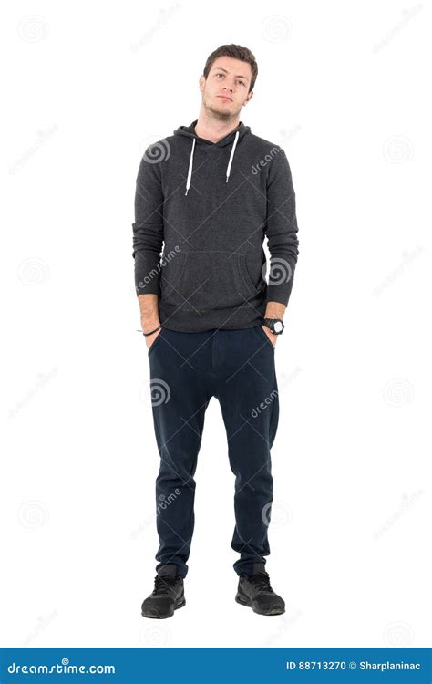 Relaxed Young Sporty Man In Hooded Sweatshirt And Sweatpants Looking At