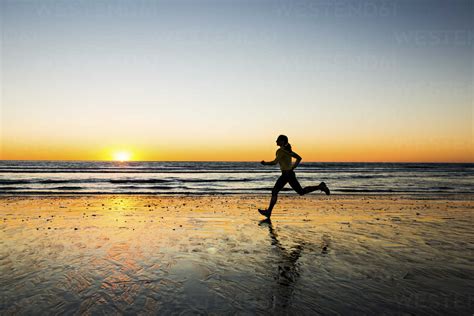 Woman Running On Beach Stock Photo