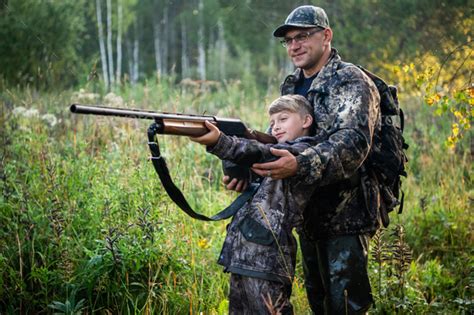 Father Teaching His Son About Gun Safety And Proper Use On Hunting In