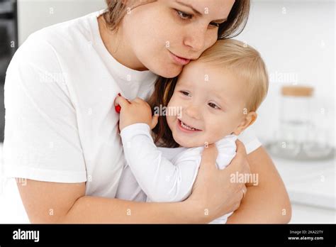 A Loving Mother Cuddling Her Baby At Home A Vivid Portrait Of A Happy