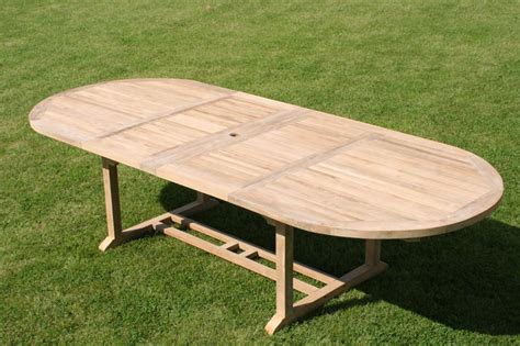 An easy pull of the sides reveals a butterfly extension that easily folds up and into place. Oval extending teak garden dining table | Parasol hole ...