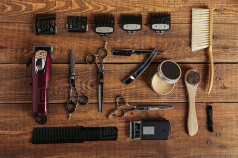 Top view of various professional barber tools on wooden surface in hair ...