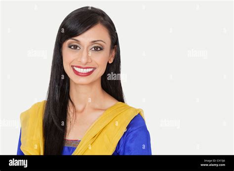 Portrait Of An Attractive Indian Woman In Traditional Wear Smiling Against Gray Background Stock