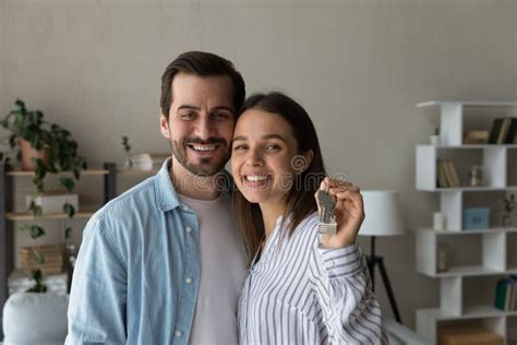 Young Couple Bought New House Showing Keys At Camera Stock Photo