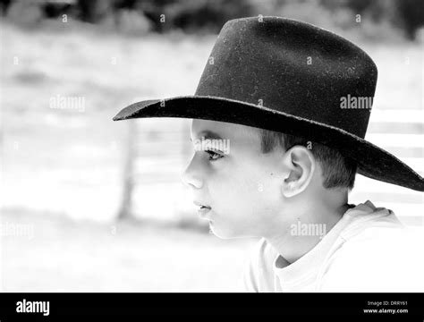 Black And White Portrait Of Young Teen Boy In Black Cowboy Hat On Ranch