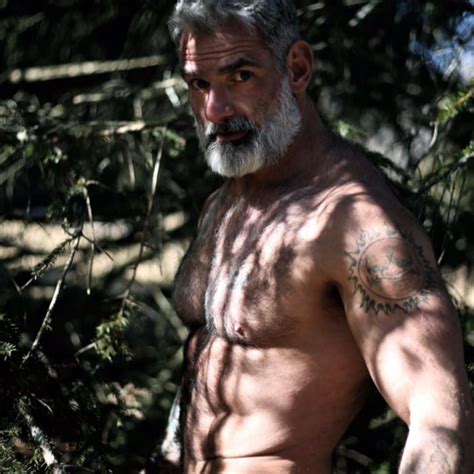 A Man With No Shirt Standing In The Woods