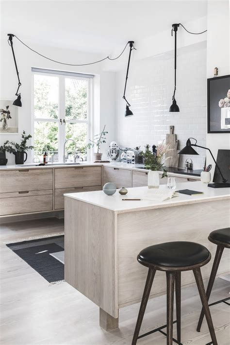 These types of kitchens tend to reflect a super refreshing, modern and clean ambiance. Light woods and clean cabinets with black fixtures ...