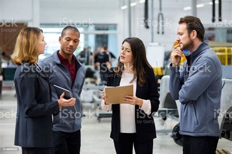 Manager Discussing With Colleagues In Car Factory Stock Photo