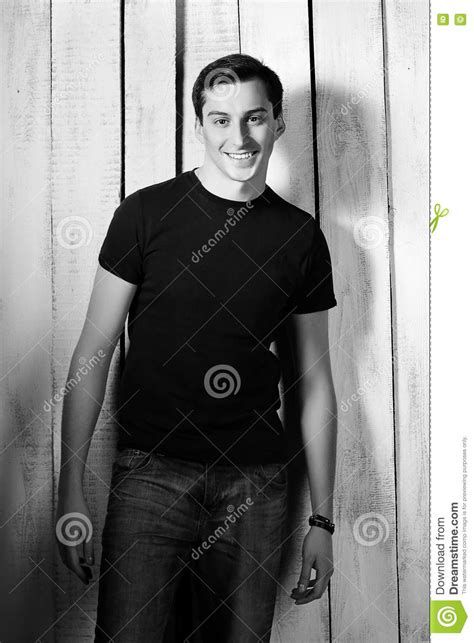 Young Man In T Shirt And Jeans On Wooden Background Stock Image