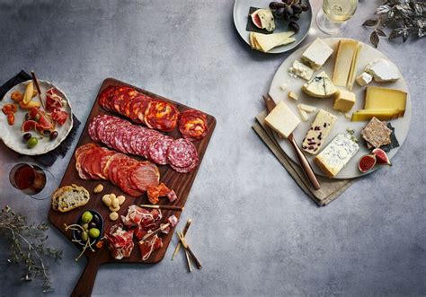 An Assortment Of Meats And Cheeses On A Table