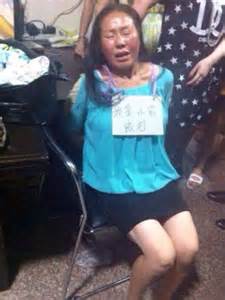 chinese shoplifter made to sit in shop window with sign around her neck daily mail online