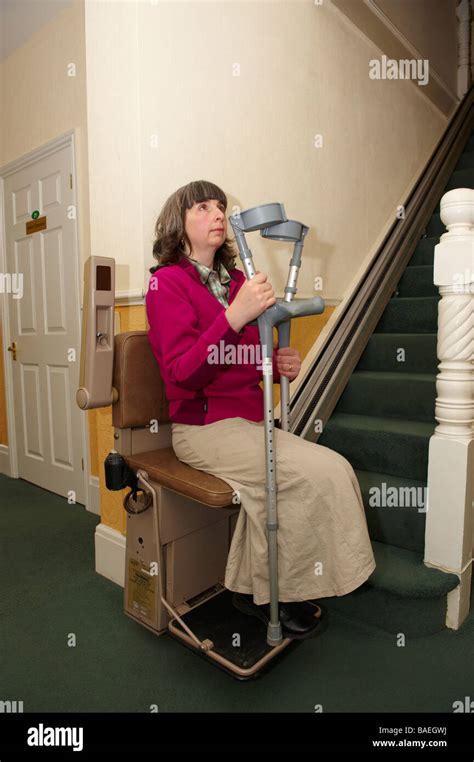 Señora Amputados Discapacitados En Silla Ascensor Con Muletas En Casa
