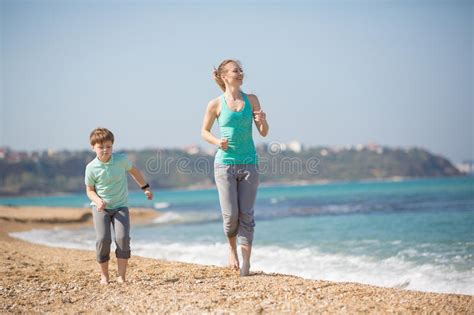 Madre Con El Hijo Que Corre En La Playa Foto De Archivo Imagen De