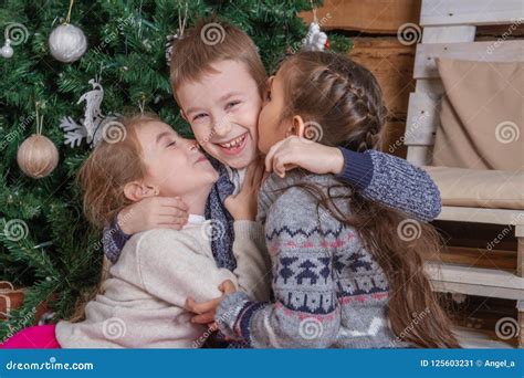 Teen Girls Kissing Brother Under Christmas Tree Everybody Laugh Stock