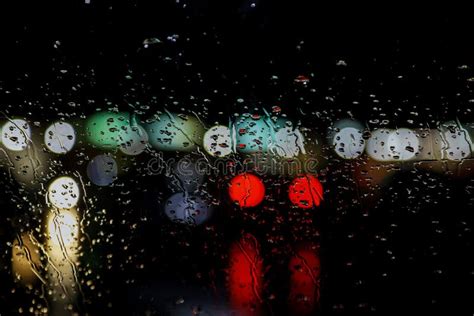 Rain Drops On Window With Road Light Bokeh In Night Rainy Stock Photo