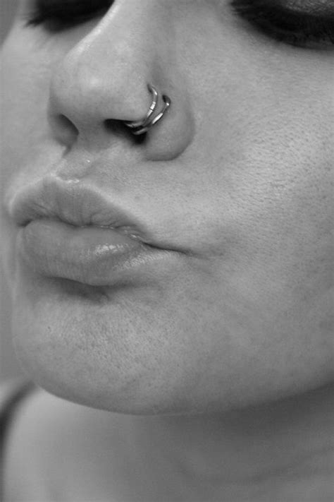 a close up of a person with a nose ring on their nose and piercing in the middle