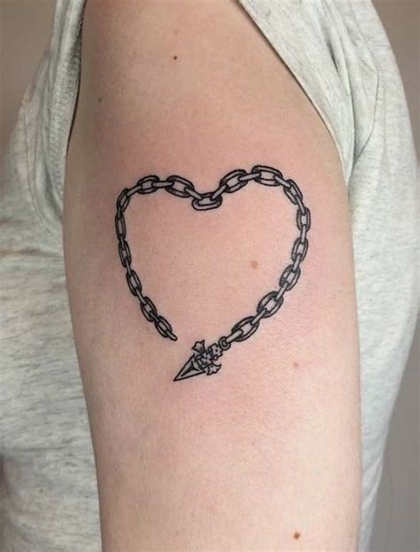 A Woman With A Heart And Chain Tattoo On Her Arm Holding A Knife In