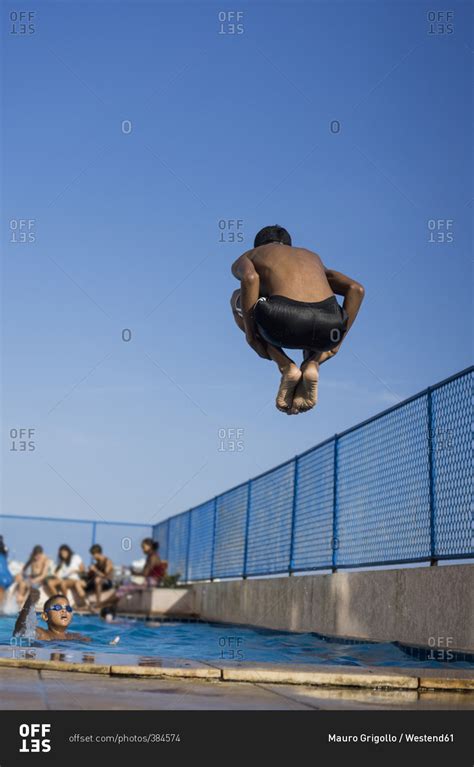Teenage Boy Doing A Cannonball Dive Into Swimming Pool Stock Photo Offset