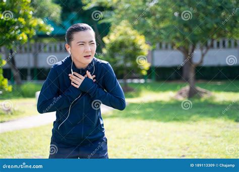 Portrait Of Asian Woman Wearing Earphones Listening To Music Was Sick With Fever At Park Stock