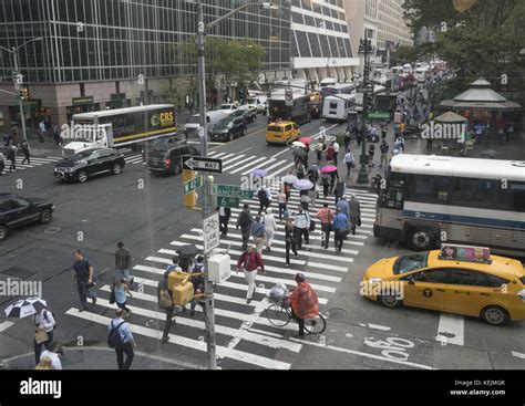 People And Traffic Cross 6th Avenue Along 42nd Street By Bryant Park In