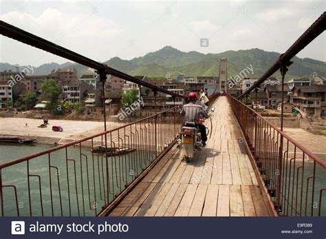a-man-driving-a-motorcycle-crossing-a-pedestrian-bridge,-shidong-stock
