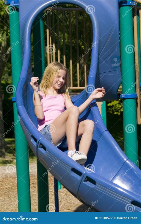 Young Girl Playing On A Slide At The Park Royalty Free Stock