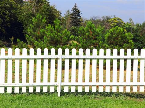 White Wooden Fence On Green Grass Against Of The Trees Stock Image