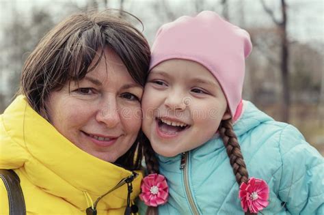 Portrait Of A Happy Mother With Her Preschool Aged Daughter Outside A