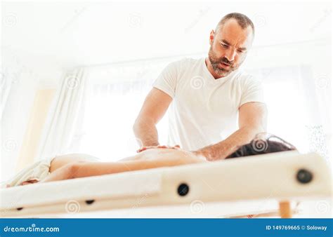 Masseur Man Doing Massage Manipulations On The Client Back And