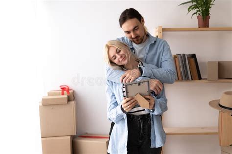 Loving Husband Hugging Wife Couple In Modern Living Room With