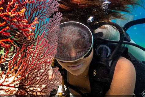 A Woman Scubas In The Water Near Coral Reefs