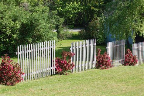 A White Picket Fence In The Middle Of A Grassy Area