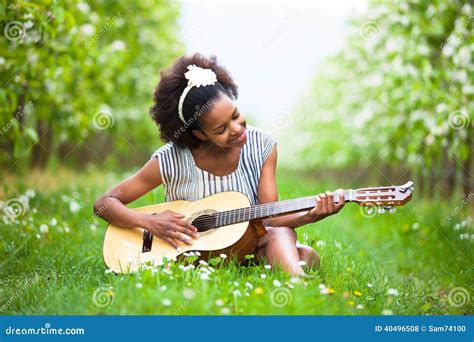 Outdoor Portrait Of A Young Beautiful African American Woman Playing