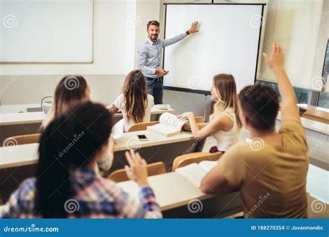 Teacher Standing In Front Of Students And Showing Something On White