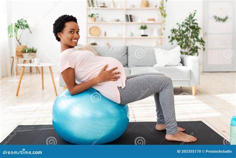 Exercising During Pregnancy Concept Positive Black Future Mother Working Out On Fitness Ball At