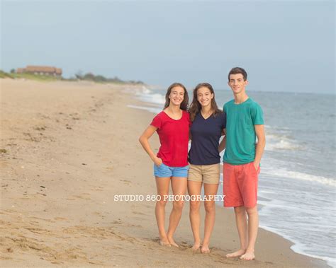 Three People Are Standing On The Beach Posing For A Photo With The