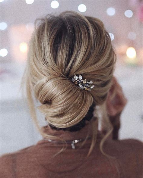 A Woman With Blonde Hair In A Low Bun