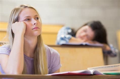 Premium Photo Bored Student Listening While Classmate Sleeping In