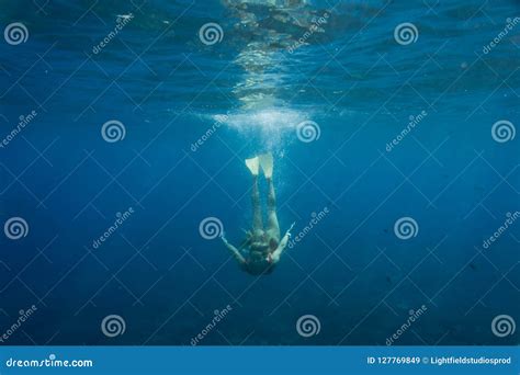 De Onderwaterfoto Van Jonge Vrouw In Het Zwemmen Past En Vinnen Duikend