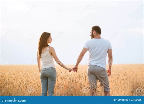Young Couple Holding Hands In The Field Stock Photo Image Of