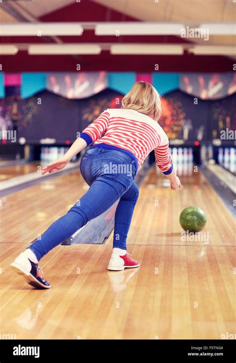 Happy Young Woman Throwing Ball In Bowling Club Stock Photo Alamy