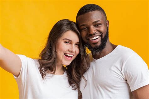 Happy Interracial Couple Taking Selfie Posing Together Over Yellow