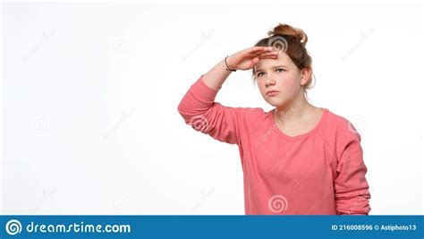 Curious Young Girl Looking Far Away With Hand At Her Forehead Trying
