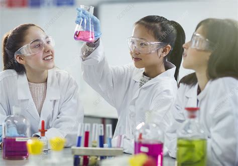 Girl Students Conducting Scientific Experiment In Classroom Stock